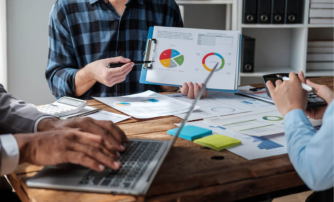 Diverse colleagues gather brainstorm discuss financial statistics at office meeting. finance, teamwork, Big data Graphs Charts concept