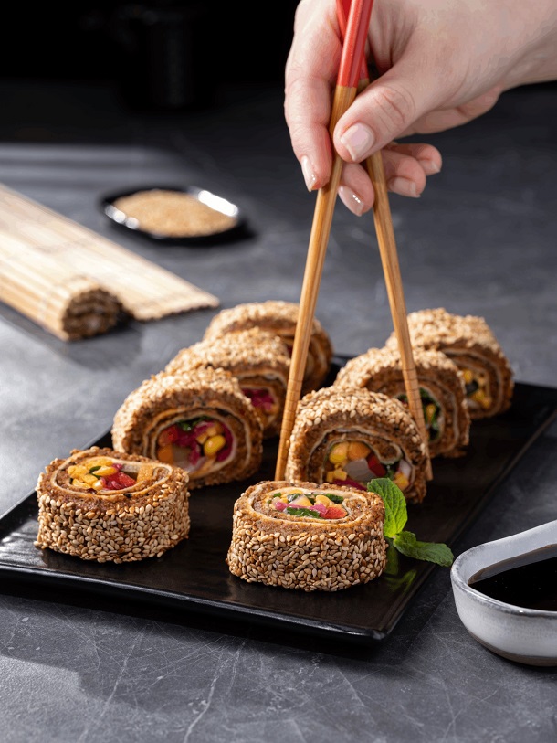 Hand with chopstick holding sushi